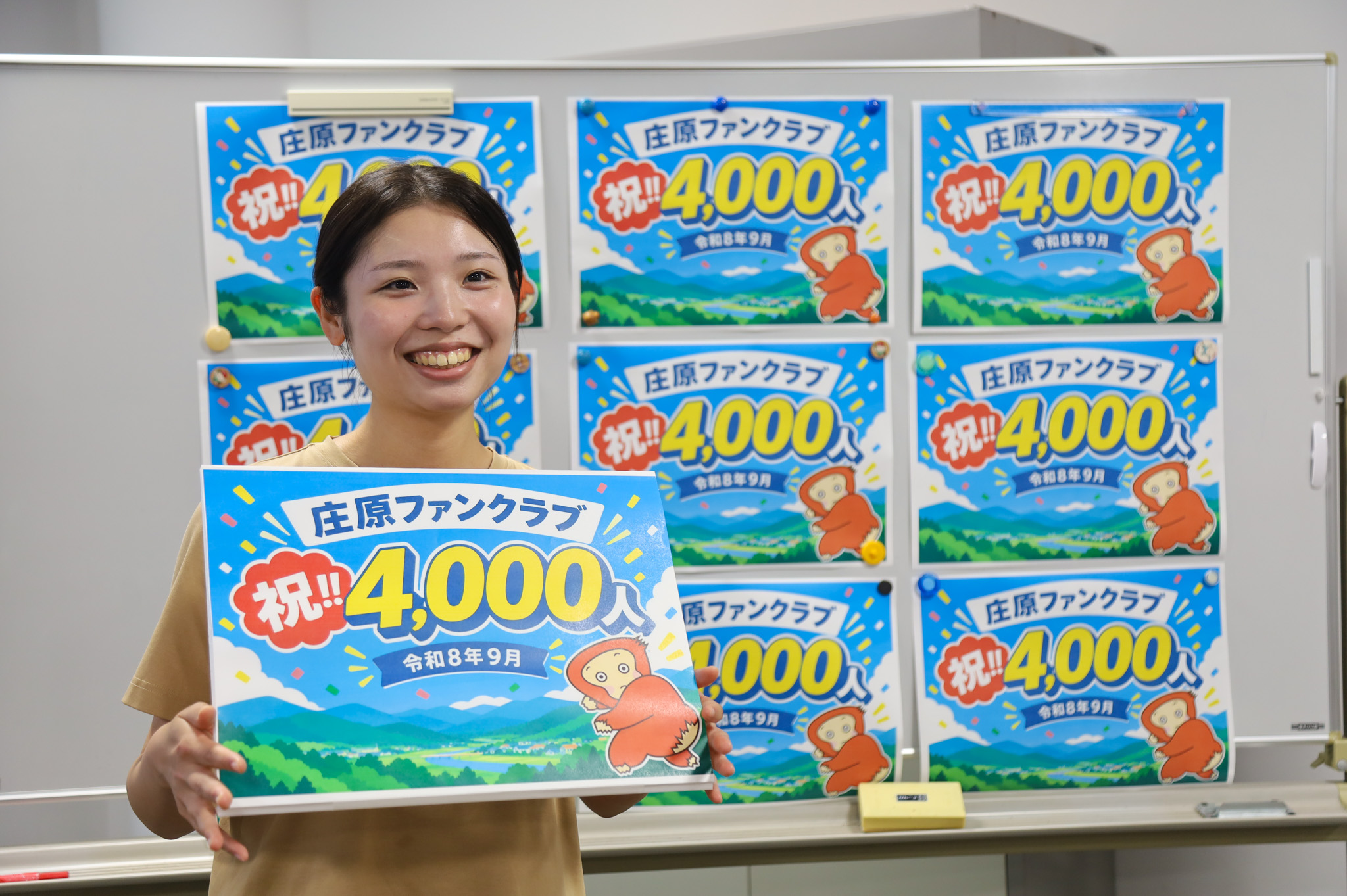 庄原ファンクラブ会員4000人達成の記念パネルを持つ山下実優さん